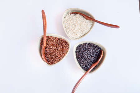 Red, black and white rice in bowlsの写真素材