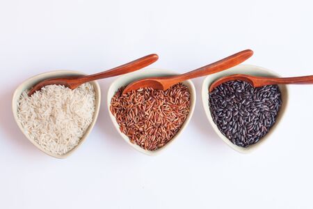 Red, black and white rice in bowlsの写真素材