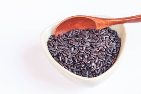 Black wholemeal rice in bowl, wooden spoonの写真素材