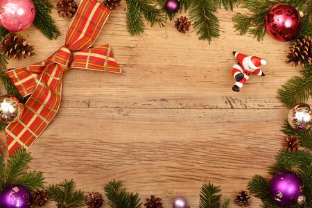 Fir twigs, ribbon and Santa Claus figurine on woodの写真素材