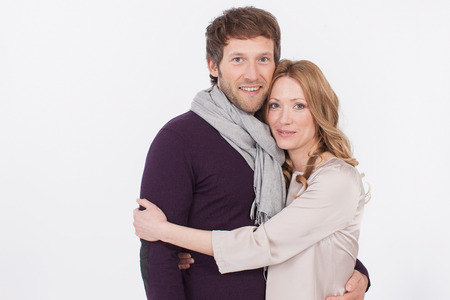 adult couple embracing against white background, smiling, portraitの写真素材