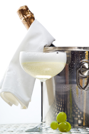 Sparkling wine in champagne cooler, champagne glass, green grapesの写真素材
