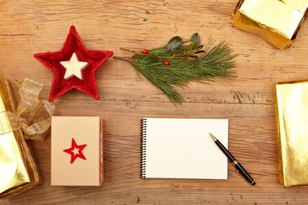 Christmas presents, notepad and fir twig on woodの写真素材