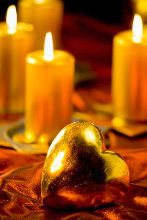 Christmas decoration, candles and golden heart on red velvetの写真素材