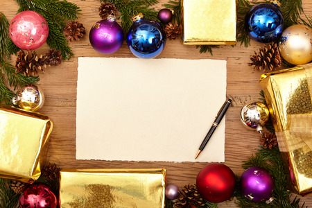 Christmas presents, fir twigs, baubles and blank card with ballpen on woodの写真素材