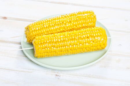 Close up of skewered corn cob in plateの写真素材