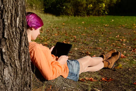 Young woman with tablet computer in parkの写真素材