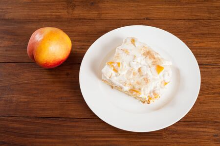 Piece of nectarine cream cake on plate, nectarineの写真素材