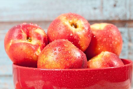 Close up of nectarines in red bowlの写真素材