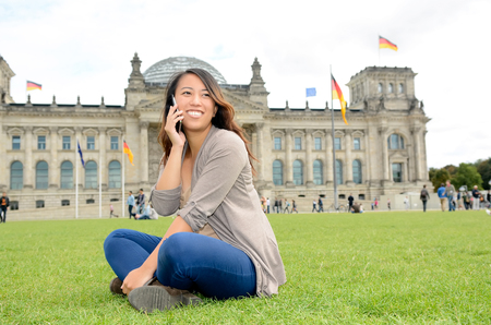 Germany, young woman with smartphone in Berlin, Reichstagの写真素材
