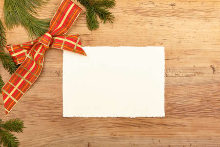 Blank card, fir twigs and ribbon, empty card on woodの写真素材