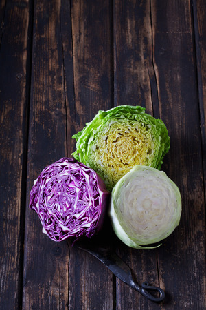 White cabbage, savoy and sweetheart cabbage, halved, on woodの写真素材