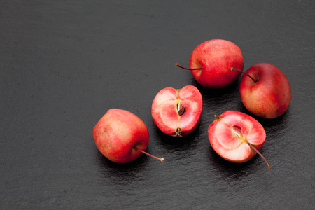 Red dwarf apples on slate, halvedの写真素材