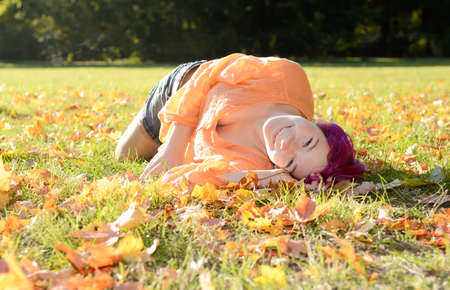 Happy young woman in park in autumnの写真素材