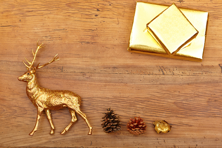 Christmas decoration, deer figure. presents and cones on woodの写真素材