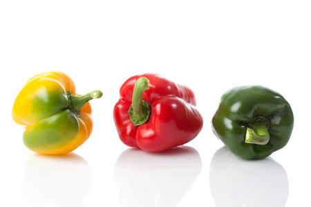Green red and yellow pepper on woodの写真素材