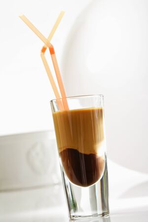 Glass of Latte macchiato with chocolate, drinking straws