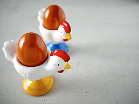 Easter, egg cup, cock figurine on concreteの写真素材