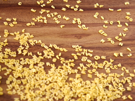 Alphabet noodles on woodの写真素材