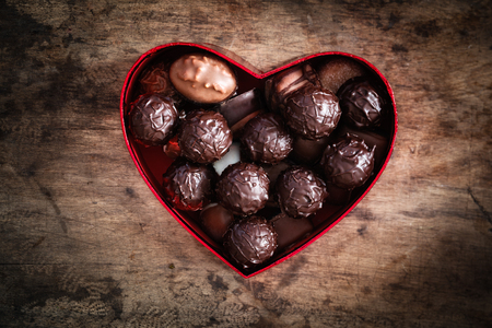 Chocolate truffles in heart shaped box on wood, valentine, mother's day presentの写真素材