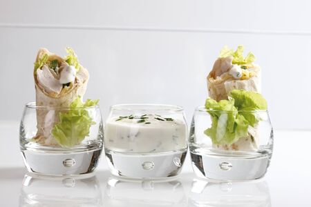 Chicken Wraps in glasses and Yoghurt dip in glassの写真素材