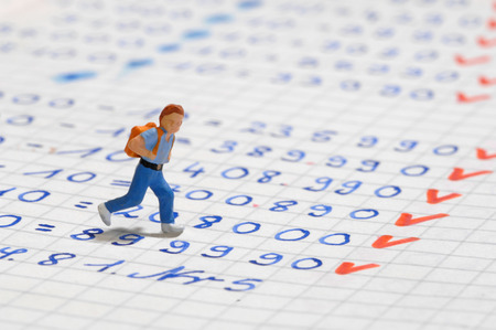 Figurine of Schoolboy walking on exercise bookの写真素材
