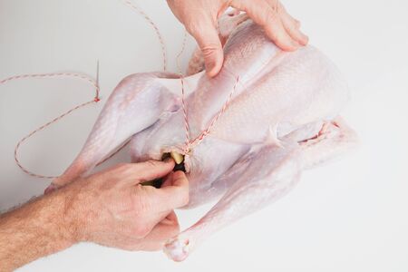 Man stuffing raw turkey, Thanksgiving, Christmas dinnerの写真素材