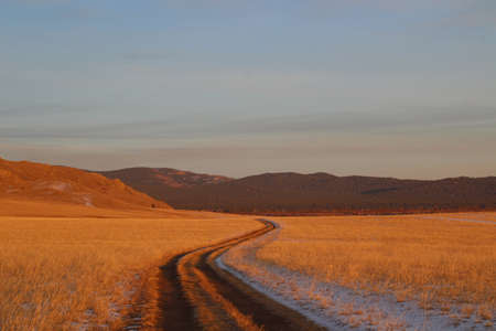 Road in the steppe. Winter landscape. Altai, Siberia, Russia