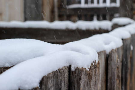 Snowcapped wooden fence in winter