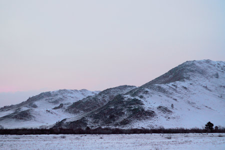 Snowcapped Mountains in Sunset light Rocky Hill Covered with White Snow in Cold Winterの写真素材