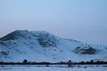 Snowcapped Mountains in Sunset light Rocky Hill Covered with White Snow in Cold Winterの写真素材
