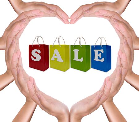 sale label on shopping  paper bag in hands heartの写真素材