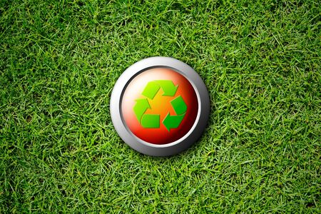 recycle button on green grass textureの写真素材