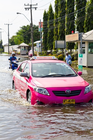 Bangkok-Nov 08 : Taxi drives in water flood road. Nov 08, 2011, Thailand , Bangkok, panya road and prayasuren road intersectionのeditorial素材
