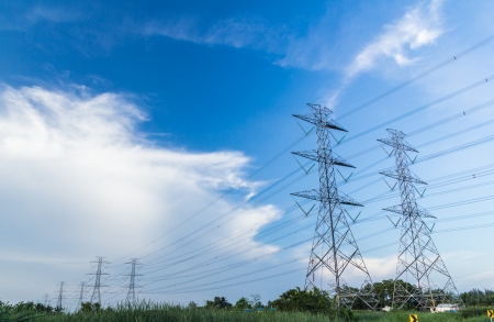 electricity high voltage power post against blue skyの写真素材