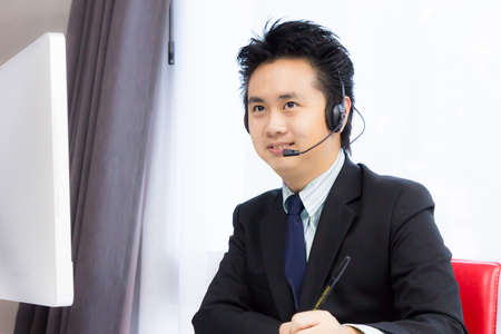 smiling business man working with desktop computerの写真素材