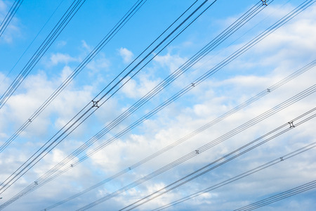 high power voltage cable line against blue skyの写真素材