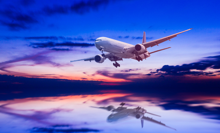 air plane flying on the sea at duskの写真素材