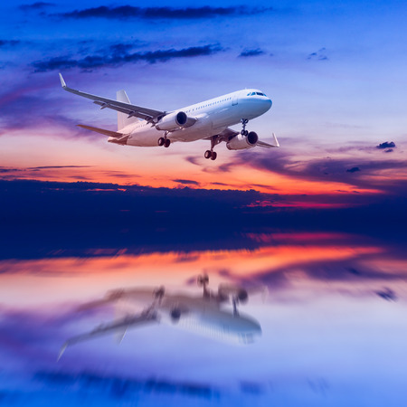 air plane flying on the sea at duskの写真素材