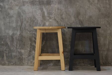 Wooden chairs natural brown and black located in front the smooth plaster walls.の写真素材