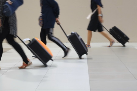 Blur and movement of people dragging suitcases in a hurry.の写真素材