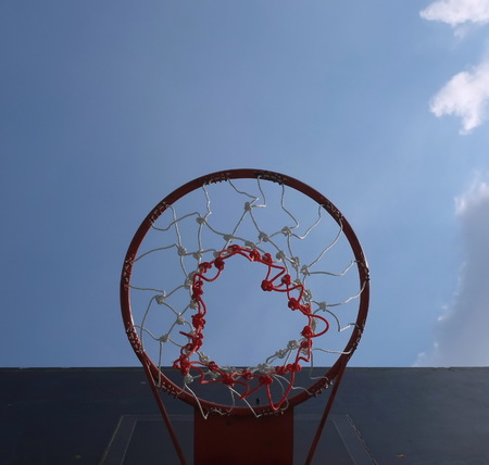 Basketball hoop under the sky before noon.