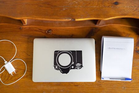 laptop, charger and bloc on a wood tableの写真素材
