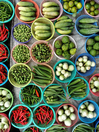 fresh vegetable, chillis, cucumber, thai eggplants, green okla, lemons, kaffir lime, green, red, blue, basketの写真素材