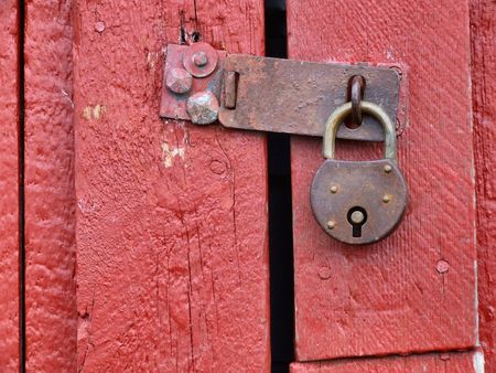 Old rusty padlock on a wooden door in Norway.の写真素材