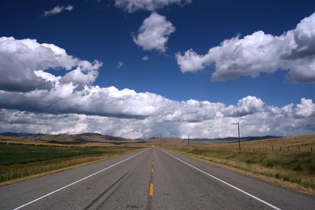 Straight, endless road in Canadian prairie. Landscape of Alberta province in Canada.