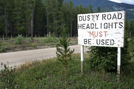 "Dusty road" roadsign on a gravel route in British Columbia, Canada. Near Valemount.の写真素材