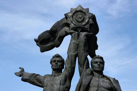 Russian and Ukrainian worker holding up The Soviet Order of Friendship of Peoples. Famous monument in Kiev, Ukraine, made of bronze.の写真素材