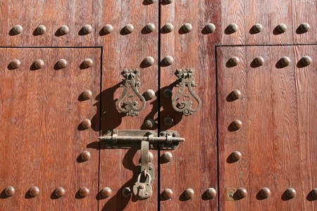 Wooden door of a church in Almeria, Spain. Old architecture - knocker, bolt, padlock.の写真素材