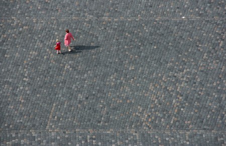 Mother and a child walking an empty street or square. Symbolic concepts of family, loneliness, solitude, social isolation, exile, refugee.の写真素材